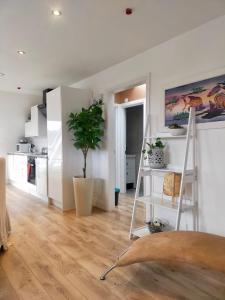 een keuken met witte kasten en een plant in een kamer bij Stunning Luminous Penthouse/ 2Beds 2Baths in Bournemouth
