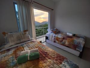 a bedroom with two beds and a large window at Ibiza Reservado 201 in Melgar