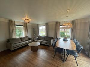 a living room with a couch and a table and chairs at Vakantiepark Eigen Wijze in Bant