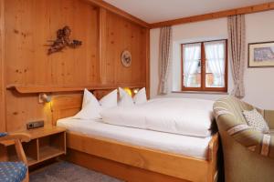 ein Schlafzimmer mit einem Bett und einem Stuhl in einem Zimmer in der Unterkunft Beim Gschdoaga in Mittenwald