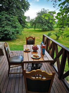 una mesa de madera con platos de comida en una terraza en Gospodarstwo Agroturystyczne "Dom na kolonii", en Prostki