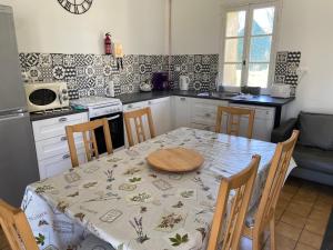 uma cozinha com uma mesa com uma toalha de mesa em Lavender Cottage em Gorges