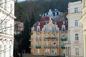 a yellow building in the middle of a city at Hotel Villa Lauretta in Karlovy Vary