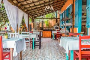 restauracja ze stołami i krzesłami w pokoju w obiekcie Vilarejo do Perequê w mieście Ilhabela