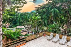une terrasse avec des chaises, des arbres et une clôture dans l'établissement Vilarejo do Perequê, à Ilhabela