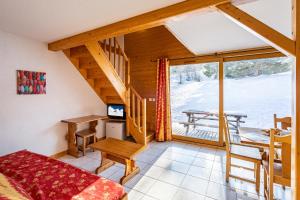 a room with a staircase and a desk and a table at SUNWEB Hôtel Chalet Margot in Le Dévoluy