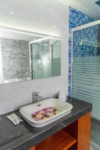 a bathroom with a bath tub with flowers on a counter at Ari Grand Hotel & Spa in Dhangethi