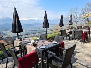 a restaurant with tables and chairs with mountains in the background at Hotel Viktor in Viktorsberg