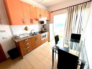 a kitchen with orange cabinets and a glass table at ALCAMAR APARTMENT! with beautiful views of the sea! in Alcalá