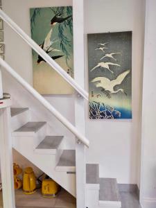 białe schody z obrazami ptaków na ścianie w obiekcie Cute & Cosy Loft-Style Studio close to Beach w Bournemouth