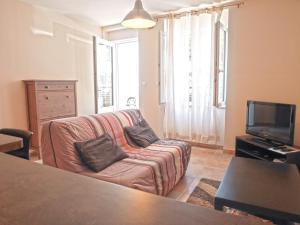 ein Wohnzimmer mit einem Sofa und einem TV in der Unterkunft Appartement Le Palais, 2 pièces, 3 personnes - FR-1-418-95 in Le Palais