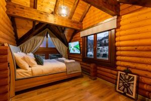 1 dormitorio con 1 cama en una cabaña de madera en Evritos Villas & Suites with pool en Karpenision
