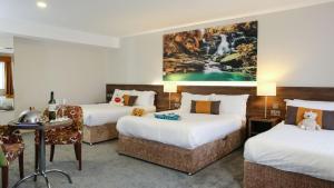 ゴールウェイにあるNox Hotel Galwayのベッド2台とテーブルが備わるホテルルームです。
