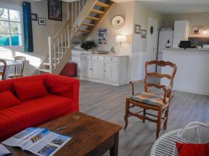 a living room with a red couch and a chair at Maison lumineuse avec jardin à Sauzon, proche plage - FR-1-418-70 in Sauzon +6 photos