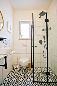 a bathroom with a shower and a toilet and a sink at lotus beach house in H̱adera