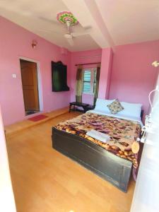 a bedroom with a bed in a pink room at Hotel Santana in Pokhara