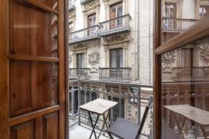 an open window with a table and a chair on a balcony at Tu Casa En Granada ideal para tu familia in Granada