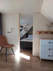 a bedroom with a bed and a desk and a chair at Zomerhuis Tuls in Egmond aan Zee