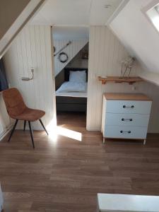 a bedroom with a bed and a desk and a chair at Zomerhuis Tuls in Egmond aan Zee