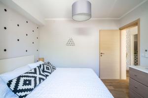 a bedroom with a white bed with a black and white pillow at Stay U-nique Studio apartment in Orašac in Orasac