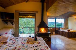 a bedroom with a bed and a fireplace in a room at Pousada Moriá in Visconde De Maua