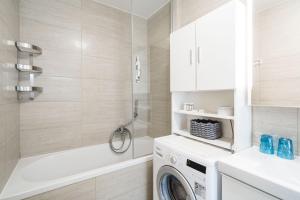 a bathroom with a washing machine and a tub at Stay U-nique Studio apartment in Orašac in Orasac