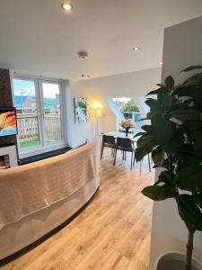 een woonkamer met een bank en een eetkamer bij Stunning Luminous Penthouse/ 2Beds 2Baths in Bournemouth