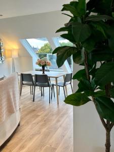 een eetkamer met een tafel met stoelen en een plant bij Stunning Luminous Penthouse/ 2Beds 2Baths in Bournemouth