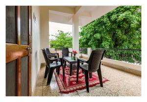 a table and chairs on a balcony with a window at Jaiswal Homestay in Jabalpur