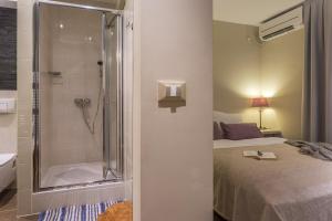 a bathroom with a shower next to a bed and a bed at Residence Antonio - Deluxe Apartments & Rooms in Rovinj +49 photos