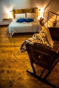 a bedroom with a bed with blue pillows and a chair at Cascina Lunguria in Francavilla Bisio
