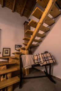 una camera con scala in legno e travi in legno di Cascina Lunguria a Francavilla Bisio