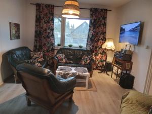 a living room with leather furniture and a window at domek u Kazi in Sadowne