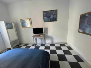 a room with a desk and a computer on a checkered floor at L’appartamento di Mango e Pistacchio in Segrate