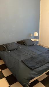 un grande letto in una camera da letto con parete blu di L’appartamento di Mango e Pistacchio a Segrate