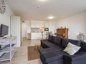 a living room with a couch and a kitchen at Spacious studio with storage room in Blankenberge