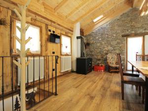 sala de estar con mesa y pared de piedra en Pleasant holiday home in Lozzo di Cadore with garden, en Vigo di Cadore