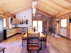 cocina y comedor con mesa de madera en Pleasant holiday home in Lozzo di Cadore with garden, en Vigo di Cadore