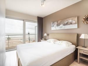 1 dormitorio con cama grande y ventana grande en Ocean Suites 501 - Appartment 2 bedrooms - floor 5, en Blankenberge