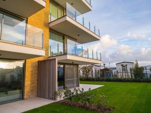 an apartment building with balconies and a lawn at Bright apartment on the first floor in Middelkerke