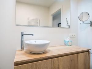 La salle de bains est pourvue d'un lavabo blanc sur un comptoir en bois. dans l'établissement Appartment 2 bedrooms with garage at Amantha 0102 on floor 1, à Middelkerke