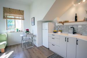 a kitchen with white cabinets and a table in it at lotus beach house in H̱adera