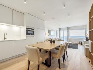 uma cozinha e sala de jantar com uma mesa de madeira e cadeiras em Costa Brava - Appartement 4 bedrooms - floor 9 em Blankenberge