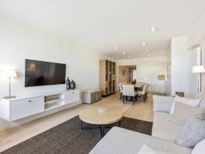 uma sala de estar com um sofá, uma televisão e uma mesa em Costa Brava - Appartement 4 bedrooms - floor 9 em Blankenberge
