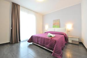 a bedroom with a purple bed with a purple blanket at Case Mistretta in Altavilla Milicia