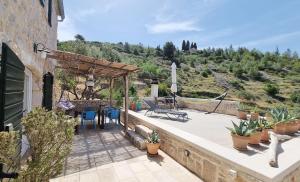 a house with a patio with a table and chairs at Agave in Veliko Grablje