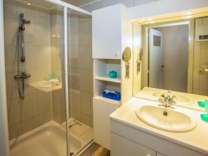ein Bad mit einem Waschbecken und einer Dusche in der Unterkunft Bella Vista 1 bedroom on floor 4 in Middelkerke