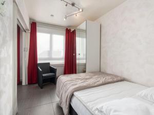 - une chambre avec un lit, une chaise et une fenêtre dans l'établissement Scarphout G6 - Studio sleeping corner - floor 6, à Blankenberge