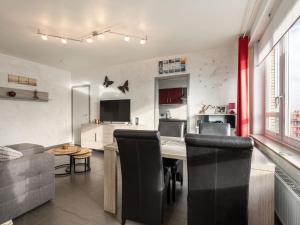 - un salon avec une table, des chaises et un canapé dans l'établissement Scarphout G6 - Studio sleeping corner - floor 6, à Blankenberge