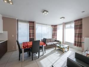 een woonkamer met een tafel en een bank bij Baros 0001 - Appartment 2 bedrooms - floor 0 in Middelkerke